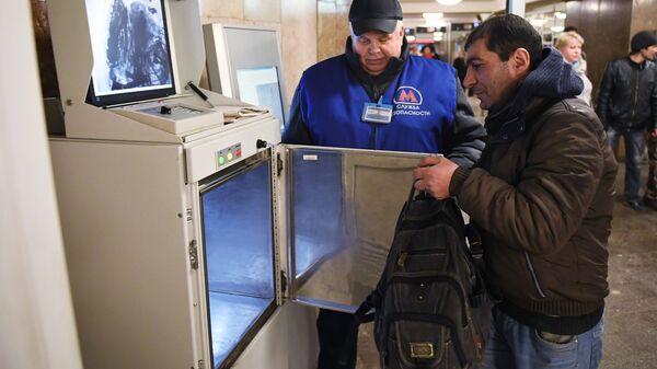 Сотрудник службы безопасности метрополитена досматривает пассажира в вестибюле станции метро в Москве. Архивное фото