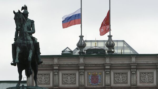 Приспущенные флаги над зданием Мариинского дворца в Санкт-Петербурге в память о погибших в результате взрыва в петербургском метрополитене