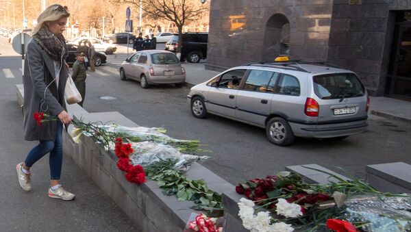 Девушка возлагает цветы у посольства РФ в Ереване в память о погибших в результате взрыва в метро Санкт-Петербурга