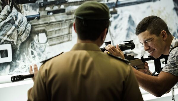 Посетитель пробует снайперскую винтовку во время выставки LAAD 2017 Defense and Security в Рио-де-Жанейро, Бразилия, 4 апреля 2017