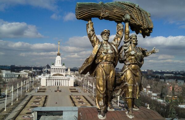Скульптура Тракторист и колхозница на триумфальной арке Главного входа Выставки достижений народного хозяйства в Москве