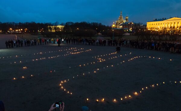 Фигура 14:40 из свечей на Марсовом поле в память о погибших в результате теракта в метро