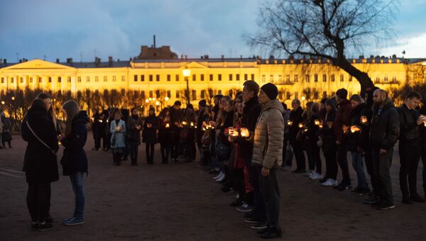 Жители Санкт-Петербурга со свечами выстраиваются в фигуру 14:40 на Марсовом поле в память о погибших в результате теракта в метро