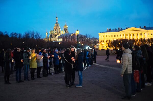 Жители Санкт-Петербурга со свечами выстраиваются в фигуру 14:40 на Марсовом поле в память о погибших в результате теракта в метро