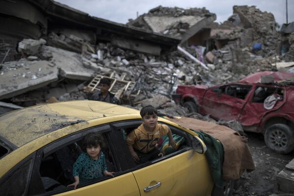 Дети играют в поврежденном автомобиле в Мосуле, Ирак