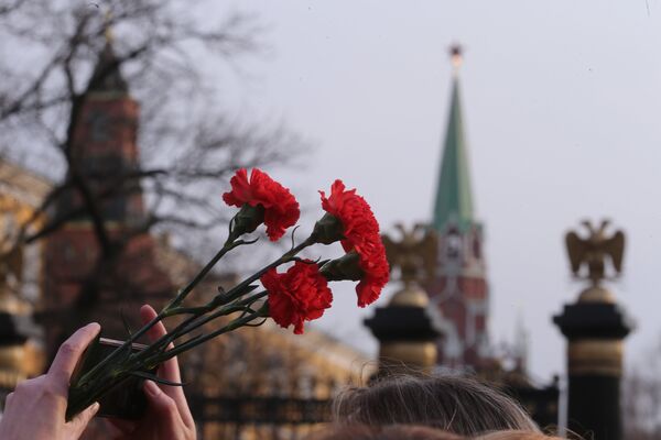 Цветы в руках участника акции памяти и солидарности Питер - Мы с тобой! в Москве