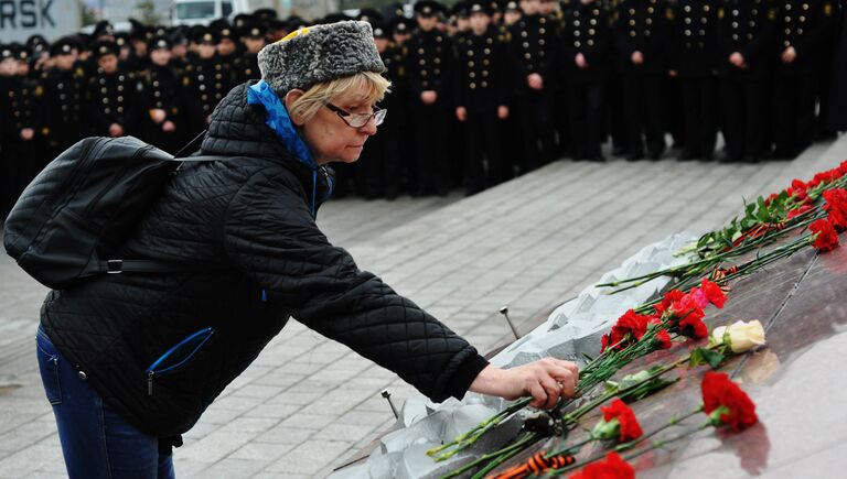 Женщина возлагает цветы к мемориалу на Корабельной набережной во Владивостоке в память о жертвах теракта в Санкт-Петербурге
