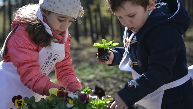 Дети высаживают цветы в клумбы в Нескучном Саду во время общегородского субботника