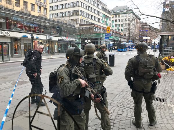 Полицейские в центре Стокгольма после наезда грузовика на людей на улице Дроттнинггатан. 7 апреля 2017