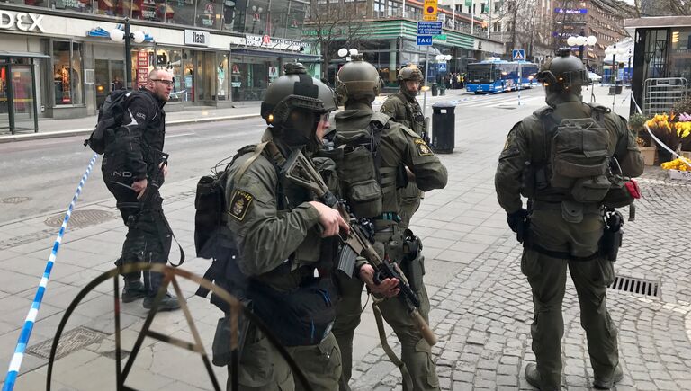 Полицейские в центре Стокгольма после наезда грузовика на людей на улице Дроттнинггатан. 7 апреля 2017