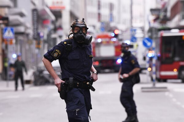 Полицейские в центре Стокгольма после наезда грузовика на людей на улице Дроттнинггатан. 7 апреля 2017