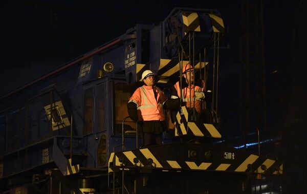 Рабочие на месте столкновения пассажирского поезда и электрички в районе улицы Герасима Курина в Москве