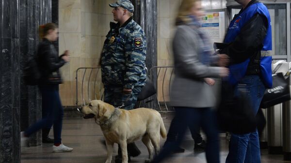 Сотрудник полиции с собакой у входа на станцию Московского метрополитена. Архивное фото