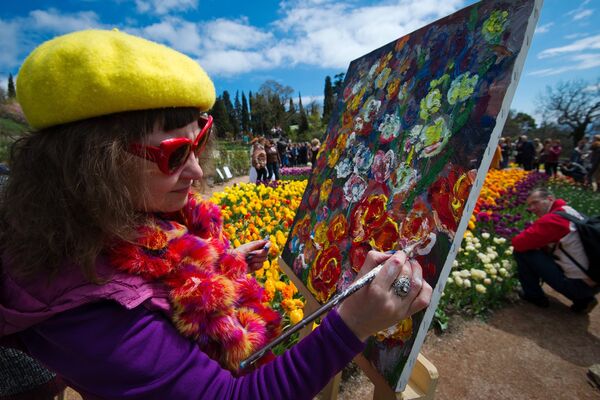 Художница пишет картину на открытии выставки Парад тюльпанов в Никитском ботаническом саду в Крыму