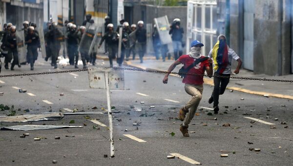 Демонстранты убегают во время протестов в Каракасе, Венесуэла. Архивное фото