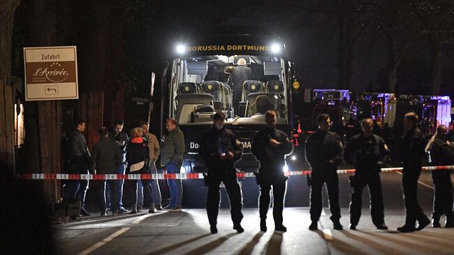 Полицейские у автобуса футбольного клуба Боруссия Дортмунд после взрыва перед матчем Лиги чемпионов. Архивное фото