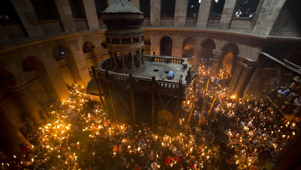 Христианские православные зажигают свечи от Благодатного огня в церкви Гроба Господня. Иерусалим, 30 апреля 2016