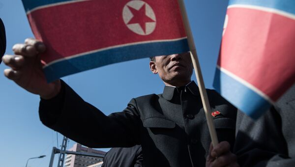 Житель Пхеньяна с флагом КНДР. Архивное фото