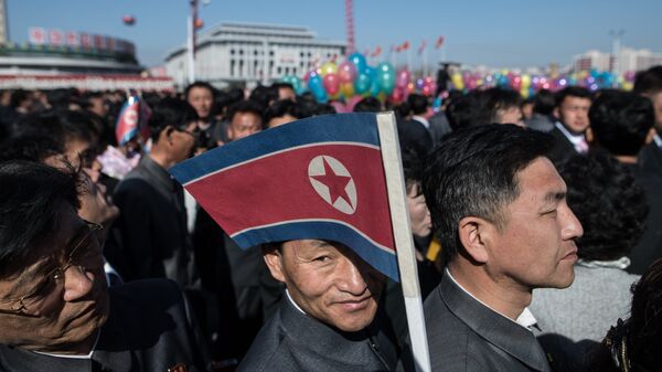 Жители Пхеньяна с флагом КНДР