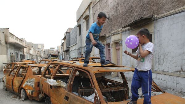 Дети играют на сожженных автомобилях в Мосуле. Архивное фото