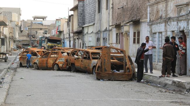 Автомобили, сожженные боевиками Исламского государства (ИГ, организация запрещена в РФ), в западной части Мосула