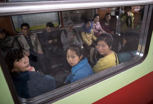 Пассажиры в вагоне поезда в метро Пхеньяна
