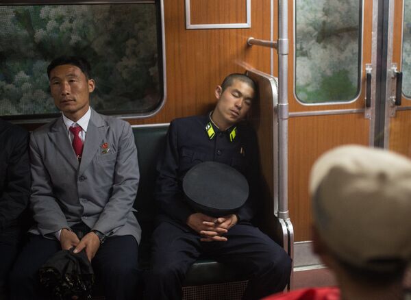 Пассажиры в вагоне поезда в метро Пхеньяна