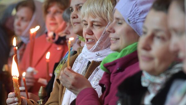 Прихожане радуются благодатному огню на праздничном пасхальном богослужении в храме Христа Спасителя в Москве