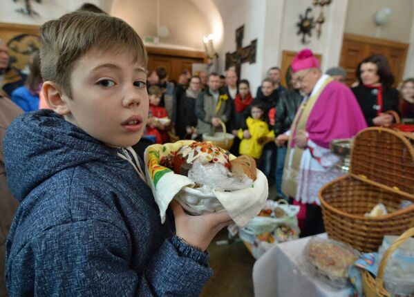 Прихожане в костеле Святой Троицы в Минске во время освящения пасхальной пищи в Великую субботу