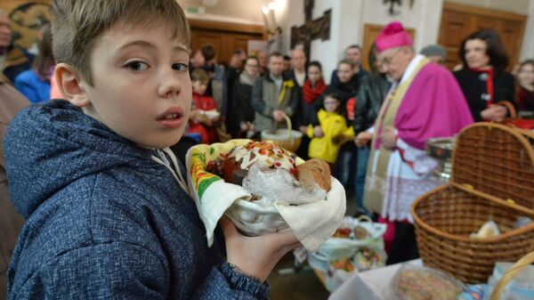 Прихожане в костеле Святой Троицы в Минске во время освящения пасхальной пищи в Великую субботу