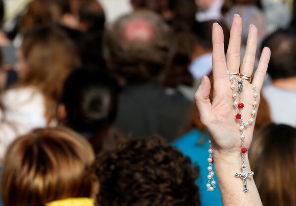 Верующий держит четки на площади Святого Петра в Ватикане на пасхальной мессе
