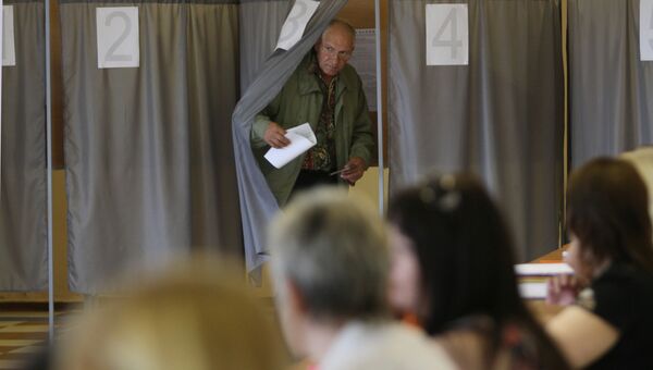 Мужчина выходит из кабинки во время голосования на выборах мэра города Омска. Архивное фото
