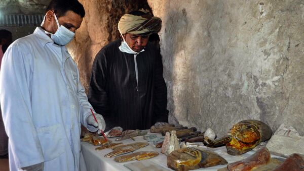 Египетские археологи рядом с артефактами, найденными в гробнице эпохи 18 династии фараонов в Луксоре. Архивное фото
