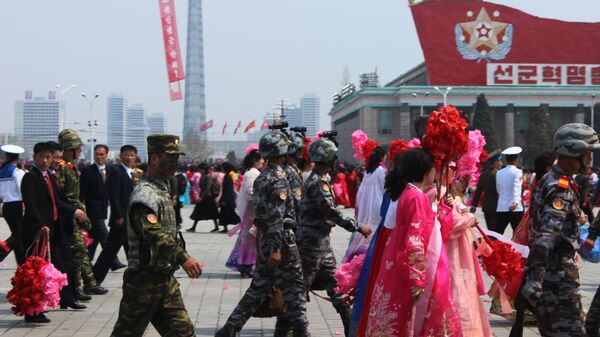 Люди после окончания парада, приуроченного к 105-й годовщине со дня рождения основателя северокорейского государства Ким Ир Сена, в Пхеньяне