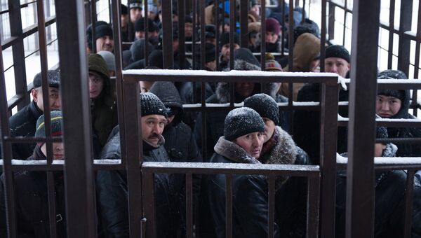 Мигранты из стран ближнего зарубежья стоят в очереди в одном из отделений УФМС по городу Москве
