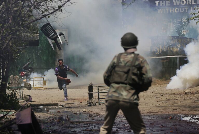 Студент кидает стул в полицейского в Кашмире, Индия
