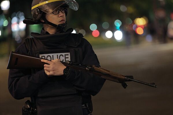 Сотрудник полиции стоит в оцеплении на месте перестрелки в Париже. Один полицейский погиб, еще один ранен при перестрелке в районе Елисейских полей в Париже