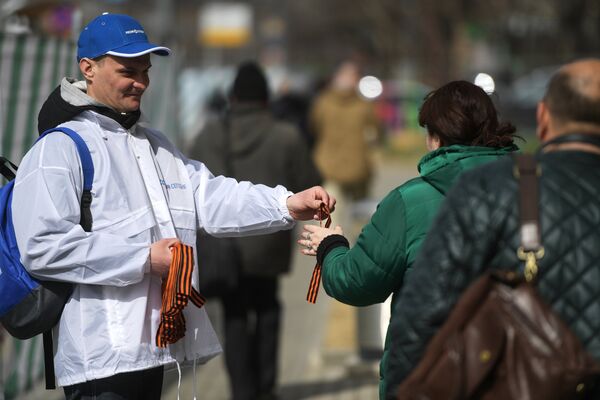 Волонтер раздает георгиевские ленточки на Зубовском бульваре в Москве в рамках стартовавшей ежегодной акции Георгиевская ленточка