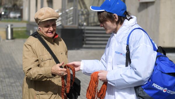 Волонтер раздает георгиевские ленточки на Зубовском бульваре в Москве в рамках стартовавшей ежегодной акции Георгиевская ленточка
