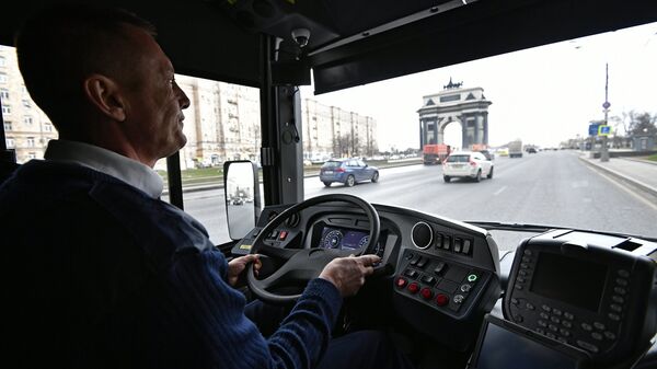 Водитель в новом электробусе с возможностью зарядки на маршруте во время презентации в Москве