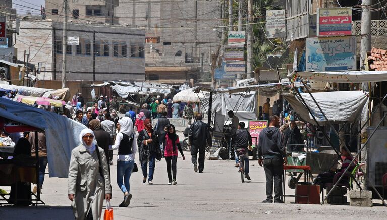 Жители на улице сирийского города Дейр-эз-Зор