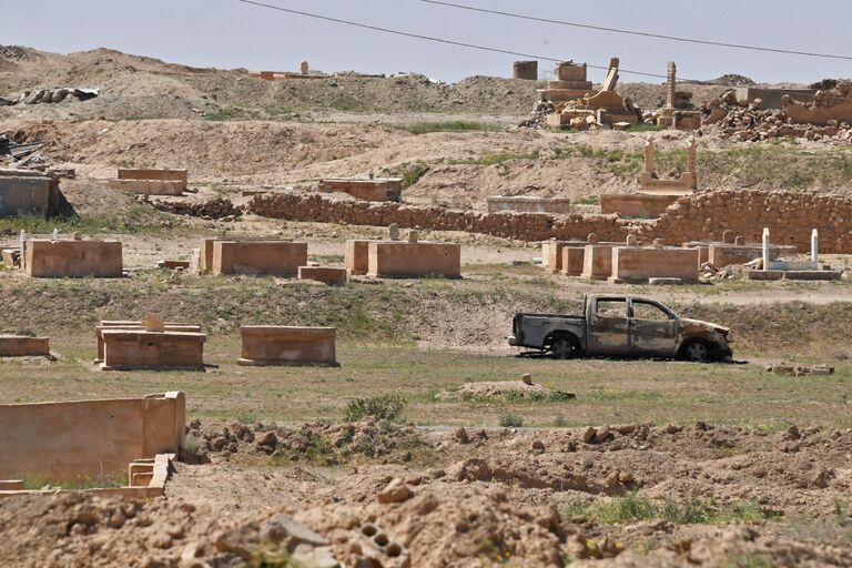 Сгоревший автомобиль на окраине сирийского города Дейр-эз-Зор