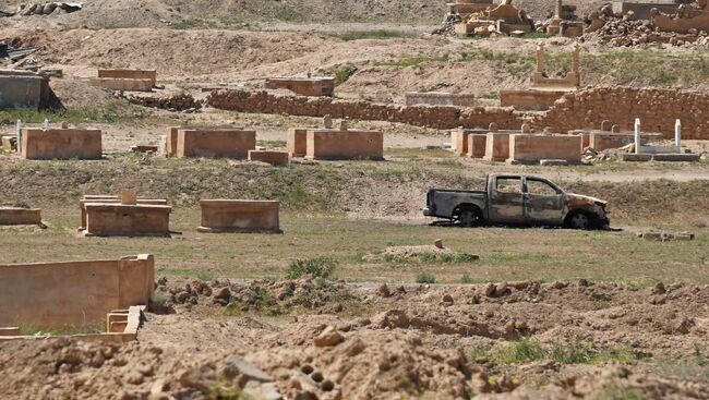 Сгоревший автомобиль на окраине сирийского города Дейр-эз-Зор. Архивное фото