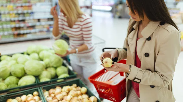Девушки покупают продукты в супермаркете