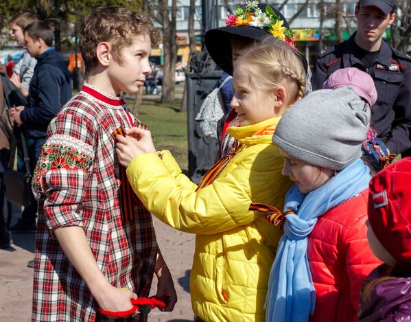 Дети повязывают георгиевские ленточки на одной из улиц в Иркутске в рамках стартовавшей ежегодной акции Георгиевская ленточка