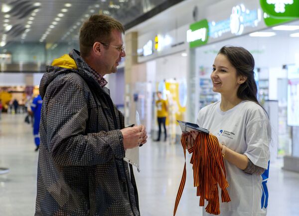 Волонтеры раздают георгиевские ленточки в аэропорту Пулково в Санкт-Петербурге в рамках стартовавшей ежегодной акции Георгиевская ленточка
