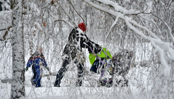 Женщина с детьми на прогулке во время снегопада в Чехии. Архивное фото