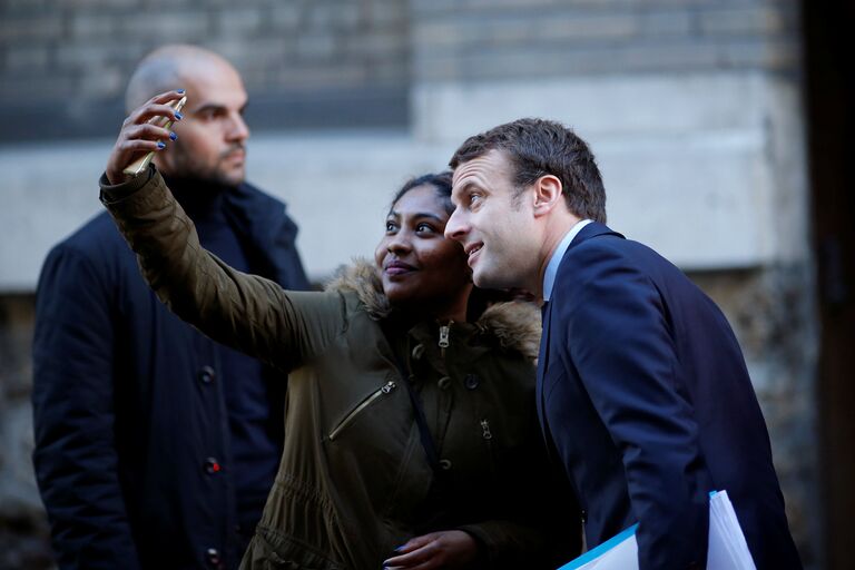 Кандидат в президенты Франции, лидер движения En Marche Эммануэль Макрон позирует для селфи у своего дома в Париже. 2 мая 2017 года Кандидат в президенты Франции, лидер движения En Marche Эммануэль Макрон позирует для селфи у своего дома в Париже. 2 мая 2017 года