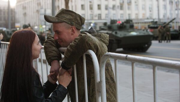 Военнослужащий с девушкой во время прохода военной техники по Тверской улице перед репетицией парада Победы на Красной площади