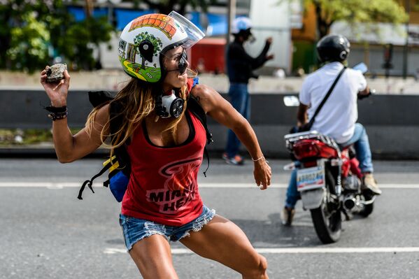 Участница марша против президента Венесуэлы Николаса Мадуро во время столкновений с полицией в Каракасе